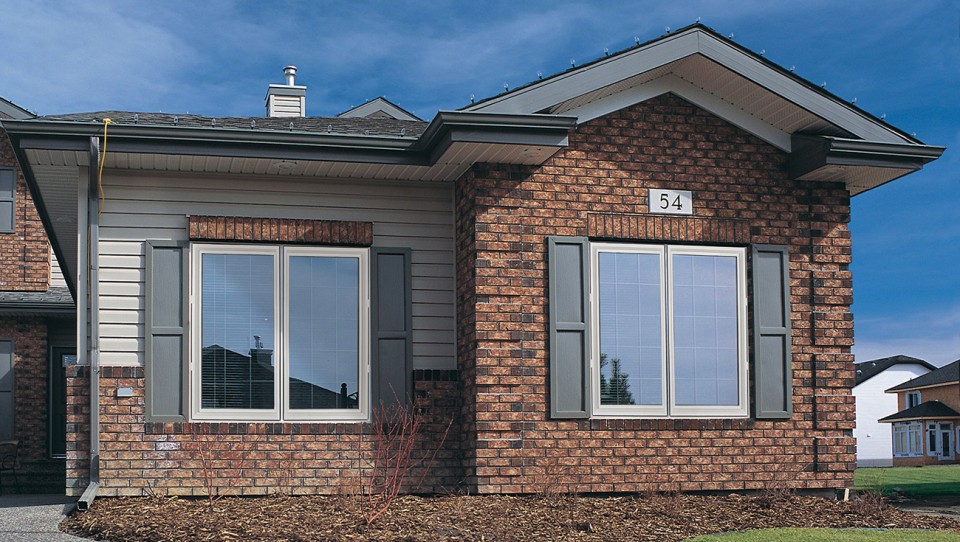 Apex 9000 windows with grey shutters on the side of a suburban home