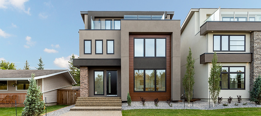 Two tri-story modern homes in a suburban neighbourhood. Both homes have glass and steel entry doors, and feature multiple windows on every storey.